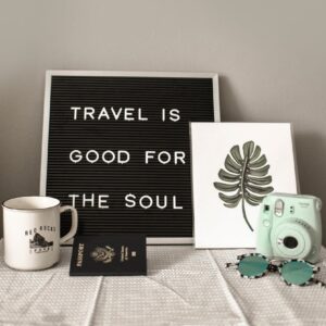 teal fujifilm instax mini camera near white ceramic mug